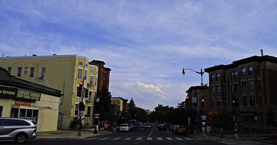 A check-cashing storefront and avenue at dusk